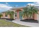Front entry of peach house with teal door at 13421 Gershwin Ln, Port Charlotte, FL 33981