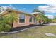 Side view of peach house with landscaping at 13421 Gershwin Ln, Port Charlotte, FL 33981