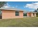View of the peach-colored house, showing a sliding glass door to a patio at 13421 Gershwin Ln, Port Charlotte, FL 33981