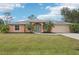 Single-story house with a teal door and palm trees at 13421 Gershwin Ln, Port Charlotte, FL 33981