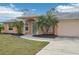 Peach house with teal door and palm trees at 13421 Gershwin Ln, Port Charlotte, FL 33981