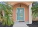 Teal front door with glass panels and a welcome mat at 13421 Gershwin Ln, Port Charlotte, FL 33981