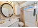 Bathroom with a shower/tub combo, vanity, and a round mirror at 1348 Reserve Dr, Venice, FL 34285