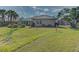 Back of house showing a large grassy area and trees at 1558 Belfry Dr, Venice, FL 34292