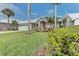 Landscaped yard with palm trees and a two-car garage at 1558 Belfry Dr, Venice, FL 34292