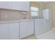 Laundry room with washer, dryer, and white cabinets at 1558 Belfry Dr, Venice, FL 34292