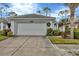 Single-story house with white garage door and lush landscaping at 1647 Lancashire Dr # 1647, Venice, FL 34293