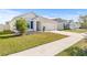 Single-story house with a white exterior, dark blue shutters, and a well-maintained lawn at 16766 Carlton Pond St, Wimauma, FL 33598