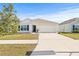 Single-story house with white exterior, attached garage, and nicely landscaped yard at 16766 Carlton Pond St, Wimauma, FL 33598
