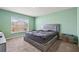 Large main bedroom with soft green walls and a king-size bed at 16766 Carlton Pond St, Wimauma, FL 33598
