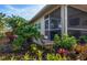 Landscaped backyard with tropical plants near the screened patio at 201 Auburn Woods Cir, Venice, FL 34292