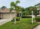 Single-story home with attached garage, palm trees, and manicured lawn at 201 Auburn Woods Cir, Venice, FL 34292
