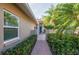 Brick walkway to teal front door, lush landscaping and gated entry at 201 Auburn Woods Cir, Venice, FL 34292