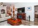 Spacious living room with hardwood floors, fireplace, and large TV at 201 Auburn Woods Cir, Venice, FL 34292