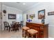 Elegant wet bar with wood cabinetry and seating at 201 Auburn Woods Cir, Venice, FL 34292