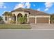 Two-story home with tile roof, three-car garage, and landscaping at 20450 Passagio Dr, Venice, FL 34293