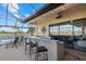 Covered patio bar with seating, overlooking a pool and lake at 20450 Passagio Dr, Venice, FL 34293
