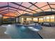 Stunning pool and patio area at sunset, complete with a bar and seating at 20450 Passagio Dr, Venice, FL 34293