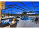 Expansive screened pool and patio with fire pit and multiple seating areas at 20450 Passagio Dr, Venice, FL 34293