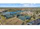 Expansive tennis and pickleball courts with surrounding green space and parking at 20450 Passagio Dr, Venice, FL 34293