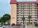 View of building entrance with parking and surrounding landscape at 232 Saint Augustine Ave # 704, Venice, FL 34285