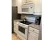 Modern kitchen with white cabinets, granite countertops, microwave, and electric cooktop at 244 Saint Augustine Ave # 805, Venice, FL 34285
