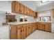 Kitchen with wood cabinets, tile floor, and a view into Gathering room at 2542 Northway Dr, Venice, FL 34292
