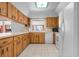 Kitchen boasts wood cabinets, tile floor, and white appliances at 2542 Northway Dr, Venice, FL 34292