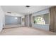 Living room featuring light blue walls, large windows, and neutral carpet at 2542 Northway Dr, Venice, FL 34292