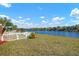 Backyard with lake view, white fence and lush grass at 2558 Hobblebrush Dr, North Port, FL 34289