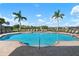 Inviting community pool with lounge chairs and palm trees at 2558 Hobblebrush Dr, North Port, FL 34289