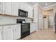 White kitchen cabinets, granite counters, and black appliances at 2558 Hobblebrush Dr, North Port, FL 34289