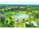 Aerial view of a spring-fed swimming area surrounded by lush greenery at 2899 Ensenada Ln, North Port, FL 34286
