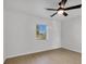 Simple bedroom with wood-look floors and a window overlooking the yard at 2899 Ensenada Ln, North Port, FL 34286