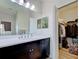 Clean bathroom with dark vanity, large mirror and walk-in closet at 295 Cassano Drive, Nokomis, FL 34275