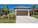 Single-story home with a two-car garage and landscaped front yard at 295 Cassano Drive, Nokomis, FL 34275