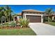 Single-story home with brown garage door and landscaping at 295 Cassano Drive, Nokomis, FL 34275