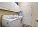 Bright laundry room, washer, dryer, and cabinets at 295 Cassano Drive, Nokomis, FL 34275