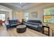 Living room with two black leather couches and ottoman at 295 Cassano Drive, Nokomis, FL 34275