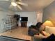Bright living room with wood floors, ceiling fan, bird cage, recliner, and television at 356 Longwood Dr, Venice, FL 34285
