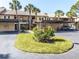 Condo building with covered parking and manicured lawn at 380 Three Lakes Ln # F, Venice, FL 34285