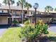 Condo building with covered parking and manicured lawn at 380 Three Lakes Ln # F, Venice, FL 34285