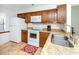 Kitchen with granite counters, wood cabinets, and white appliances at 380 Three Lakes Ln # F, Venice, FL 34285
