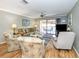 Living room with hardwood floors, balcony access, and seating at 380 Three Lakes Ln # F, Venice, FL 34285