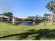 Community pond view with lush landscaping and trees at 380 Three Lakes Ln # F, Venice, FL 34285