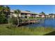 Community waterfront with a dock and lush landscaping at 380 Three Lakes Ln # F, Venice, FL 34285