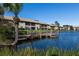 Community waterfront with a dock and lush landscaping at 380 Three Lakes Ln # F, Venice, FL 34285