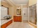 Bright bathroom featuring a glass enclosed shower, bathtub, and wooden cabinets at 4081 Roderigo Ave, North Port, FL 34286