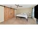 Bedroom with barn doors, ceiling fan and TV at 4200 Castlebridge Ln # 1924, Sarasota, FL 34238