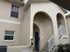 Tan building exterior with arched entryway, stairs, and white railings at 4200 Castlebridge Ln # 1924, Sarasota, FL 34238